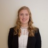 young woman in blazer smiling at camera